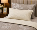 Close-up of grey floral comforter set showing pillow sham and cream stripe pillow cover